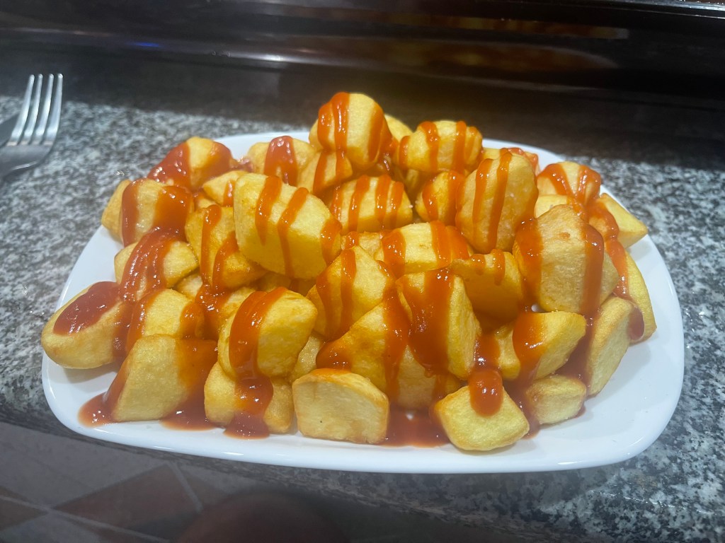 A plate of Patatas Bravas in Bar Hogar del Pensionista in Aldeanueva del Camino on the Via de la Plata, Spain.